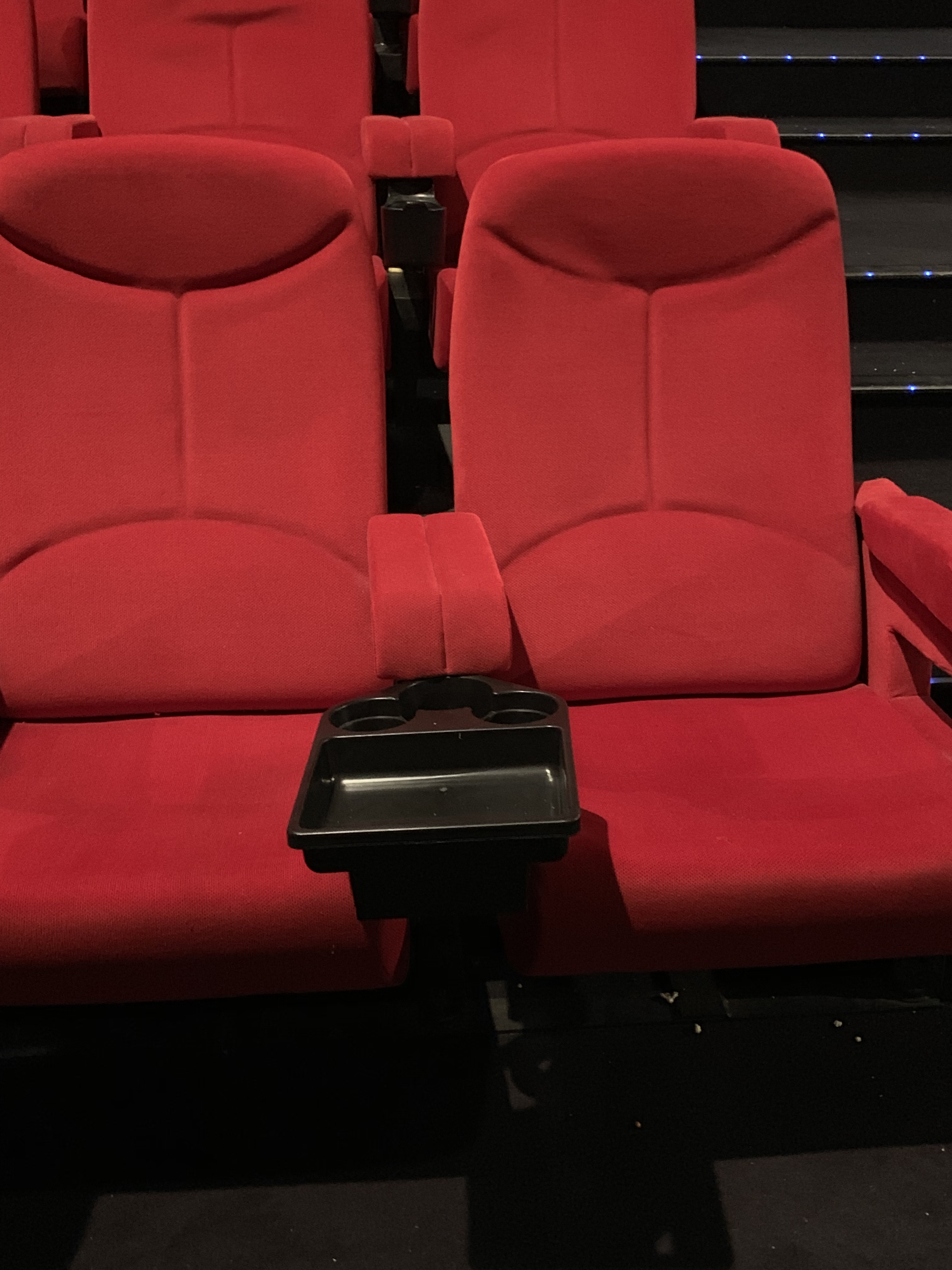 butacas de cines con bandejas portabebidas